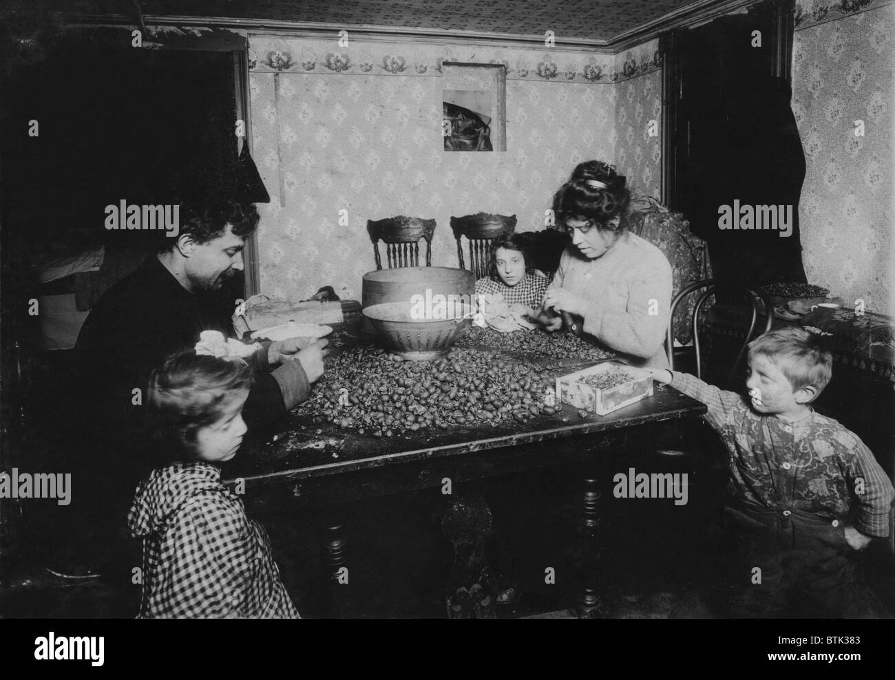 La famille de travail, légende : écrous "Ramassage en sous-sol sale, les enfants étaient plus sales que l'on puisse imaginer sur patte d'écrous, de manger le déjeuner sur la table, la mère avait un rhume, son nez fréquemment sans se laver les mains et le mouchoir sale qui reposait confortablement sur la table et à proximité de noix et noix', New York, photo de Lewis Wickes Hine, Décembre, 1911 Banque D'Images
