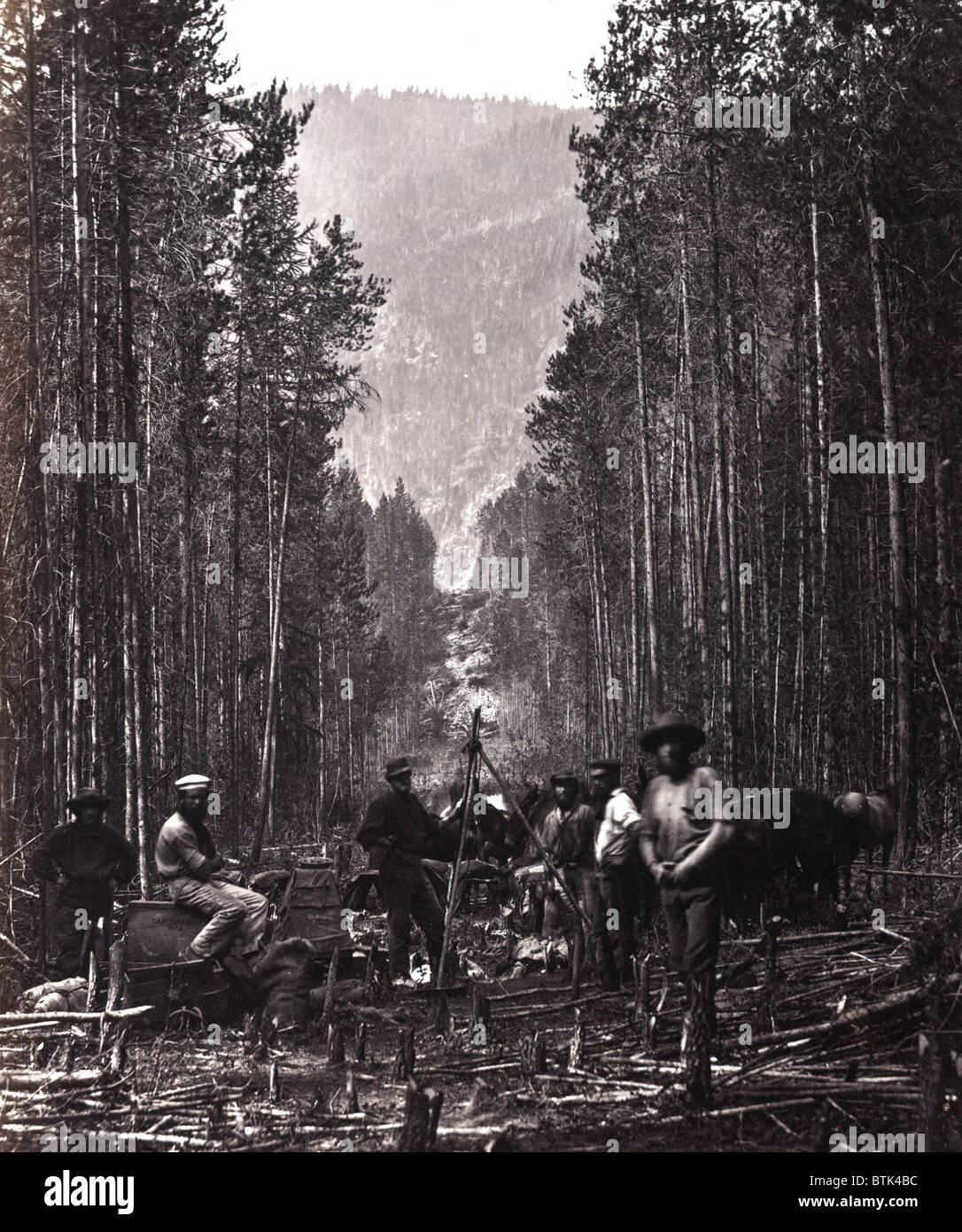 Couper la ligne frontière. Les hommes de la British North American Boundary Commission équipe de relevé posées dans la compensation, avec transport en commun, marquant la frontière entre le Canada et les États-Unis, le long de la rive droite de la rivière Moyie, Idaho. ca. 1860 Banque D'Images