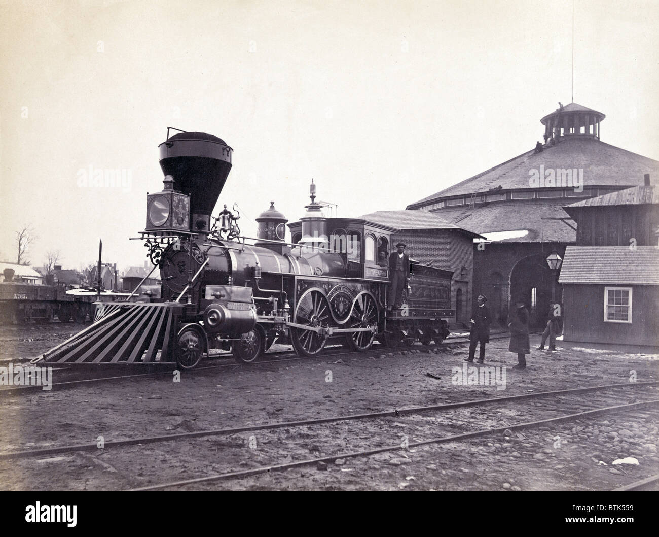 Moteur, J.H. Devereux, de l'United States Military Railroad avec deux membres d'équipage à bord de l'extérieur de la roundhouse à Alexandria le station. L'albumine, photo par Andrew J. Russell, ca. Années 1860 Banque D'Images