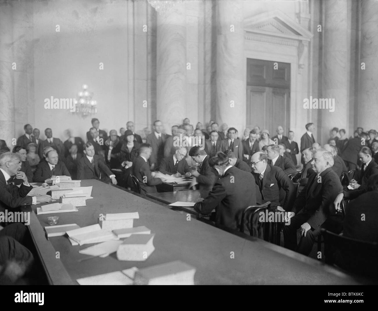 Harry F. Sinclair (1876-1956), au milieu à droite, se pencha en avant, avec des lunettes, et le sénateur Thomas Walsh (à gauche, derrière le tableau), au Comité du Sénat sur les terres publiques et d'Enquêtes enquête sur la théière Dome scandale. Mars 1924. Banque D'Images