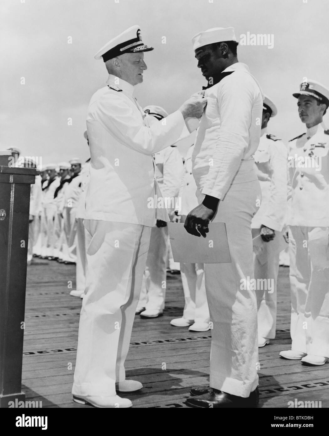 Doris 'Dorie' Miller (1919-1943), reçoit la Croix de la marine de l'amiral Chester Nimitz W. à Pearl Harbor le 27 mai 1942. Miller a été cité pour héroïsme pendant l'attaque japonaise sur Pearl Harbor et après protestation afro-américain, a été traité comme un héros blanc et affectés à un war bond tour. Plus tard, il a été tué dans la bataille de Tarawa, novembre 1943. Banque D'Images