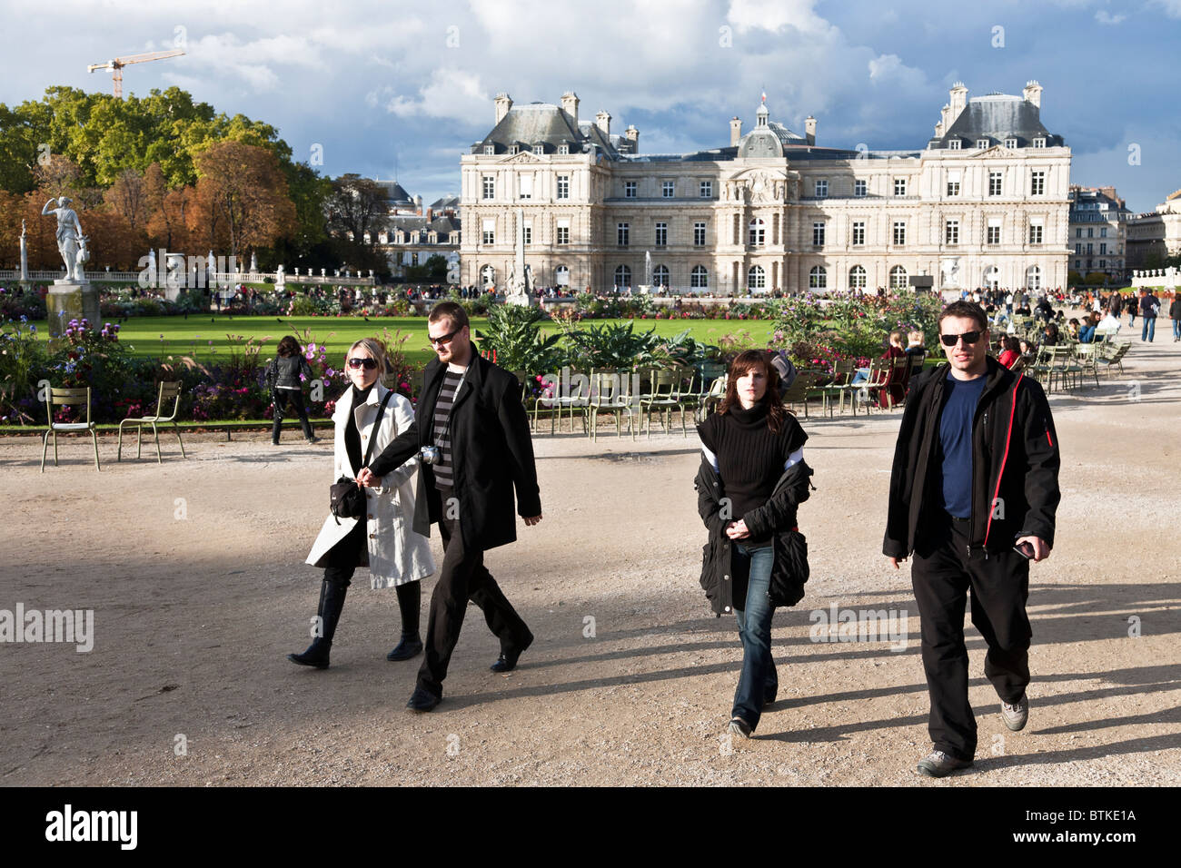 Deux jeunes couples parisiens marche à vive allure dans les jardins en face du Palais du Luxembourg sur un beau dimanche d'automne à Paris Banque D'Images