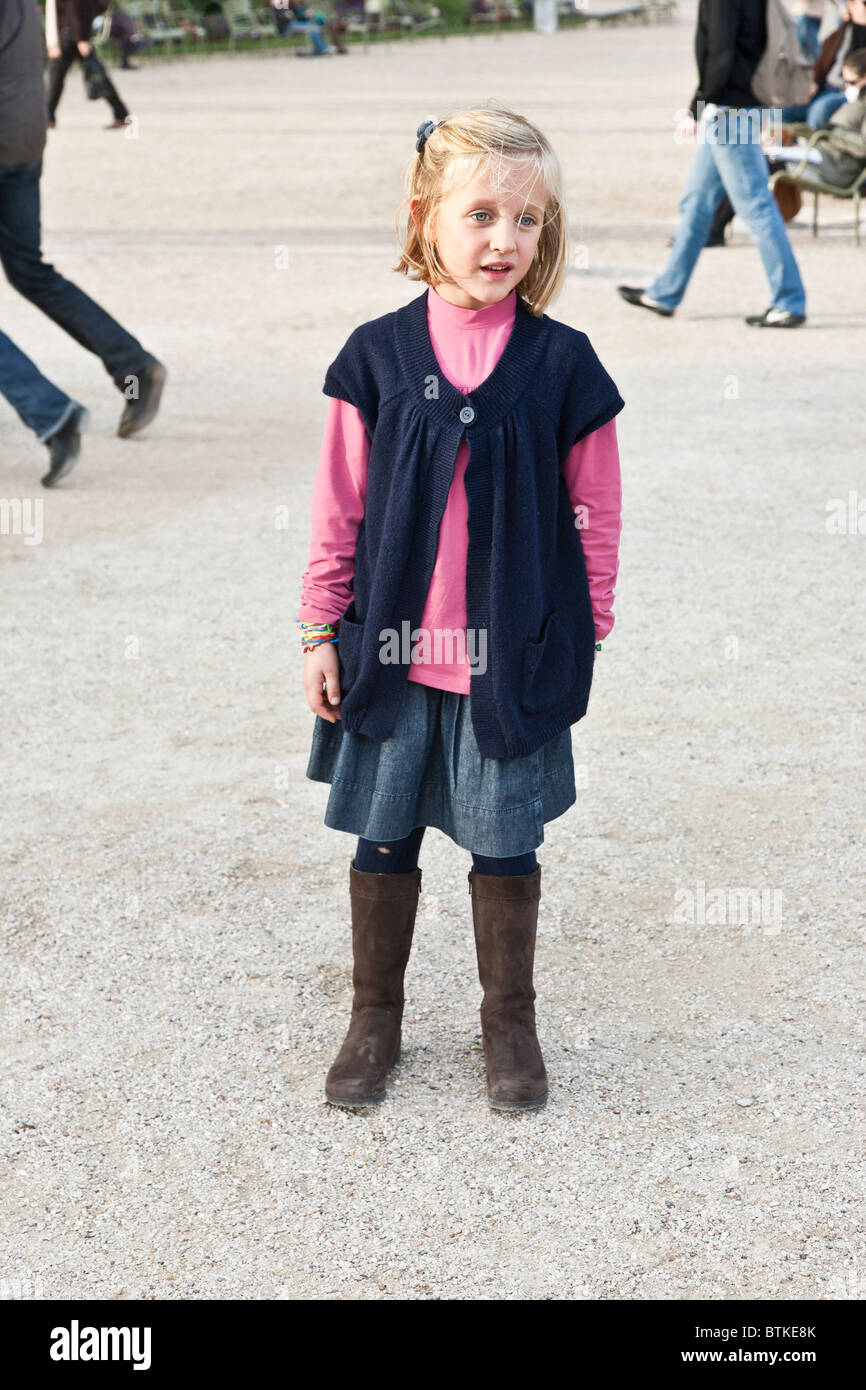 Petite fille bien habille avec des cheveux blonds yeux bleus et un trou dans son legging prend une position ferme dans les jardins du Luxembourg Paris Photo Stock Alamy