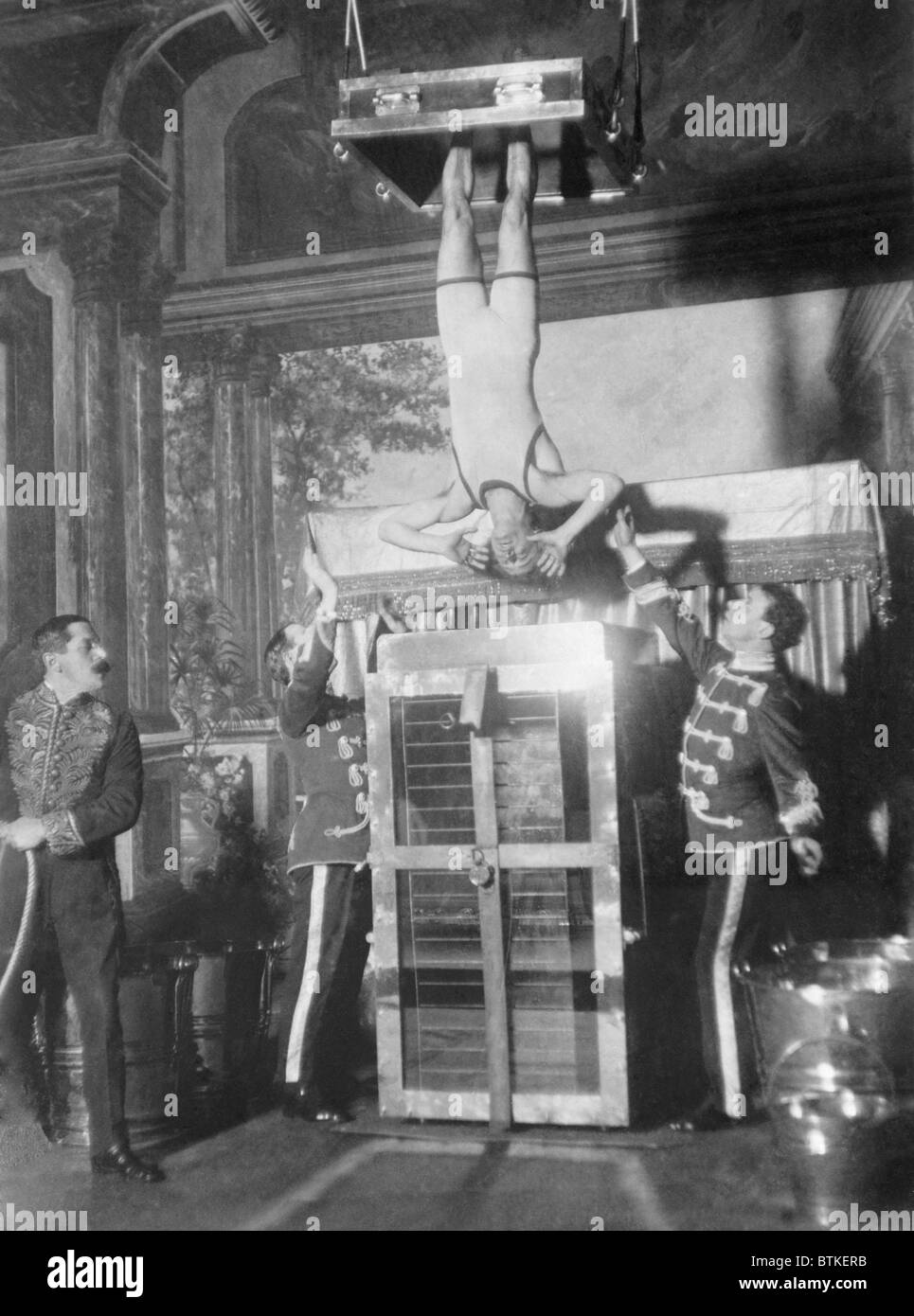 L'eau Houdini Torture Cell s'échapper. Houdini, avec ses chevilles attachés dans les stocks, a été submergé et maintenus en place à la vue du public. Ca. 1913. Banque D'Images