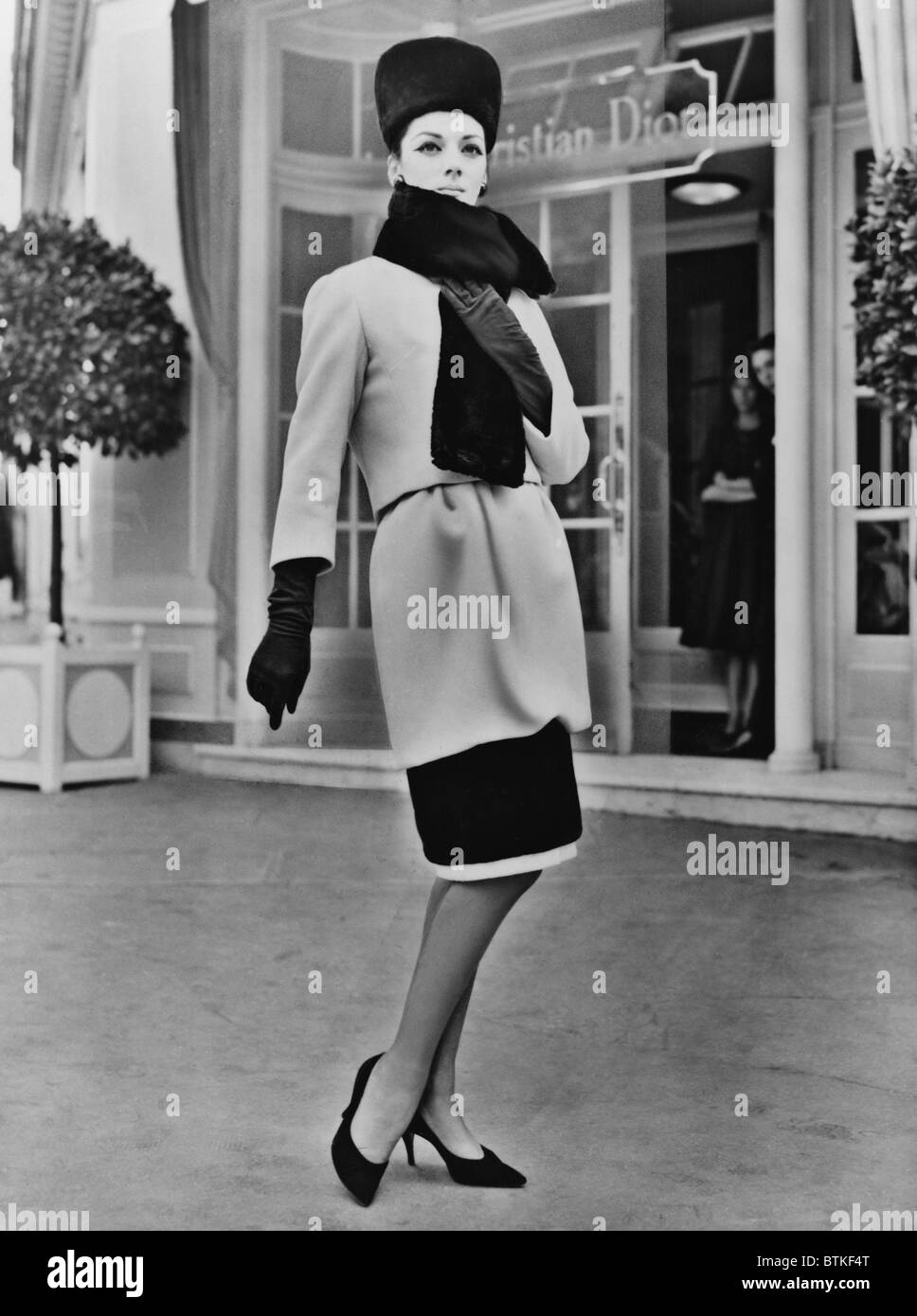 Designer français, Christian Dior inclus une courte jupe clopinent dans sa collection 1959. La conception a été accentuée par le joint noir, et porté avec des gants et un tambourin hat. Banque D'Images