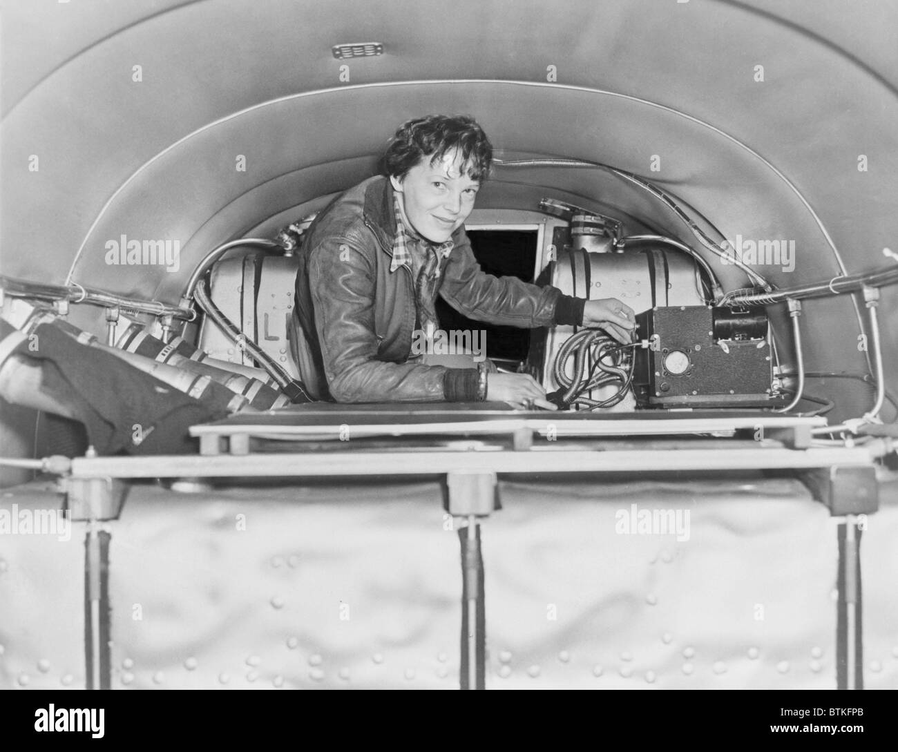 Amelia Earhart (1897-1937), vérification du matériel sur son avion. Ca. 1937. Banque D'Images
