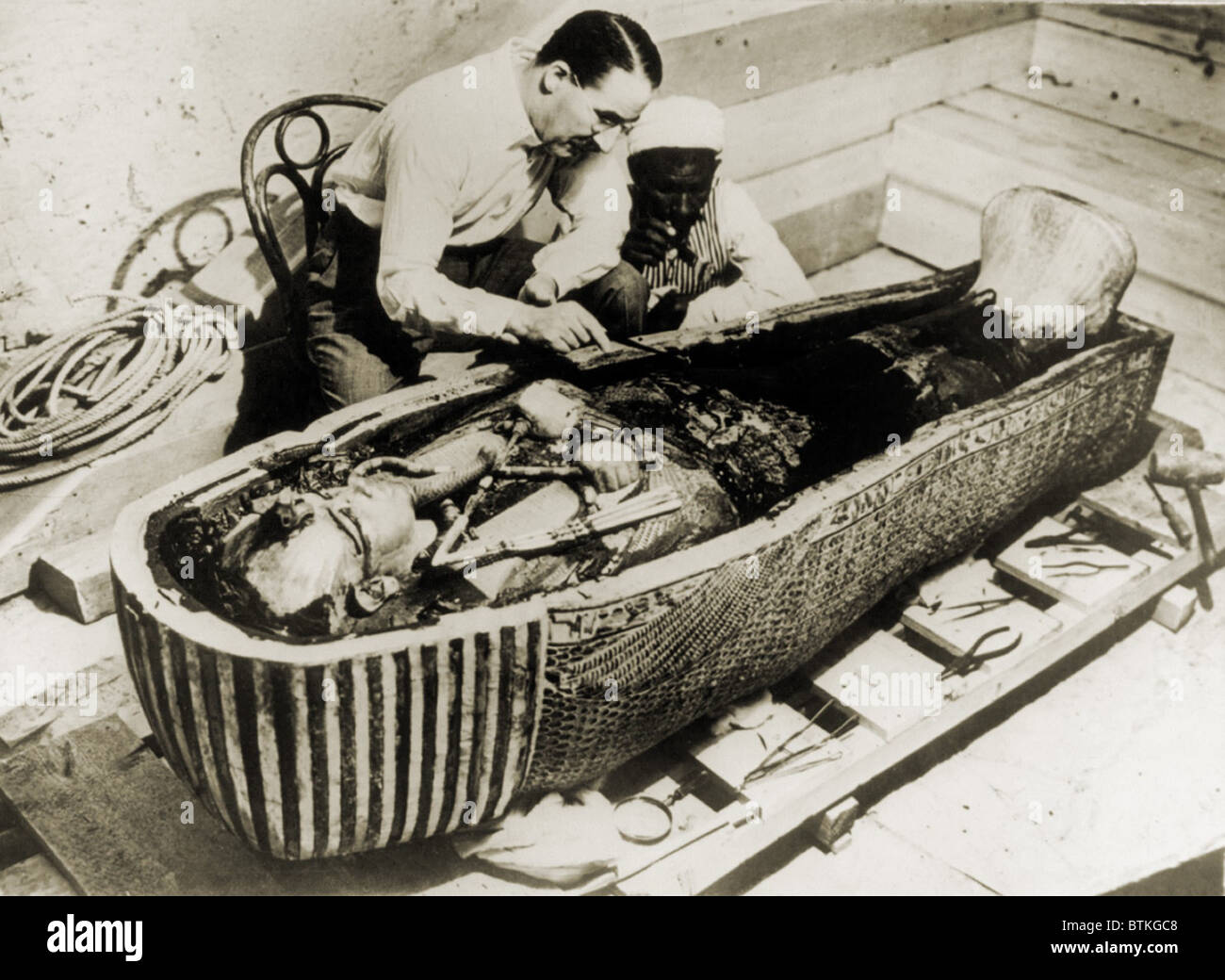 Howard Carter (1873-1939), assis à côté de cercueil du roi Toutankhamon, supprimant la consécration huiles qui concernait le troisième plus profond ou cercueil. 1926 Banque D'Images