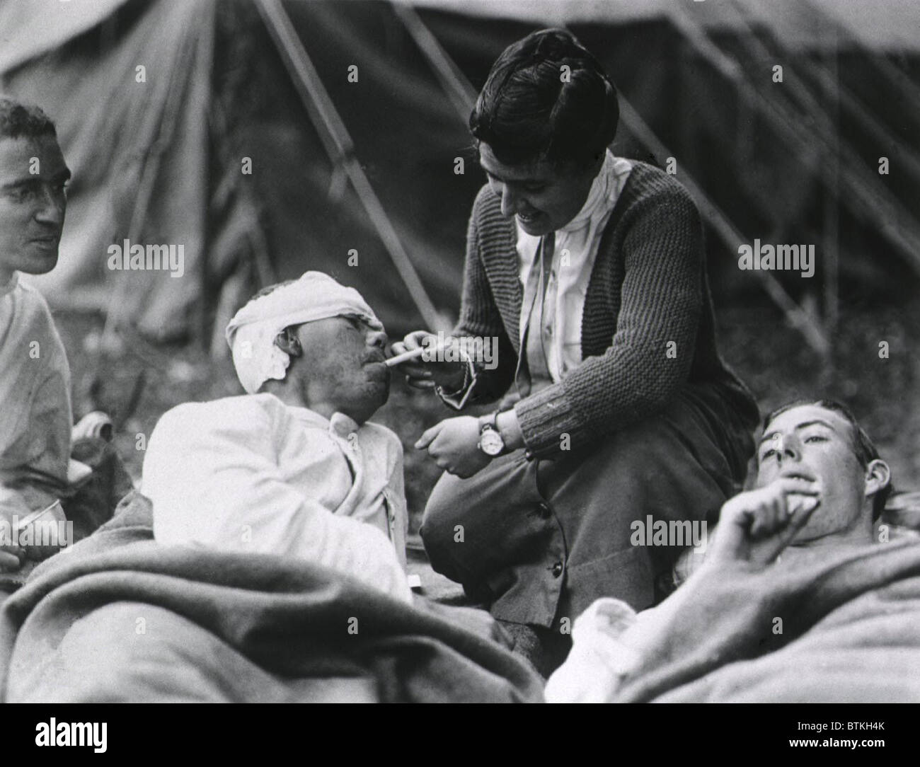 Mlle Anna travailleur de la Croix-Rouge, Rochester du Smith College, aider un soldat blessé avec sa cigarette à l'Hôpital d'évacuation de l'armée américaine, Souilly, la France pendant la Première Guerre mondiale. ca. 1917-1918. Banque D'Images