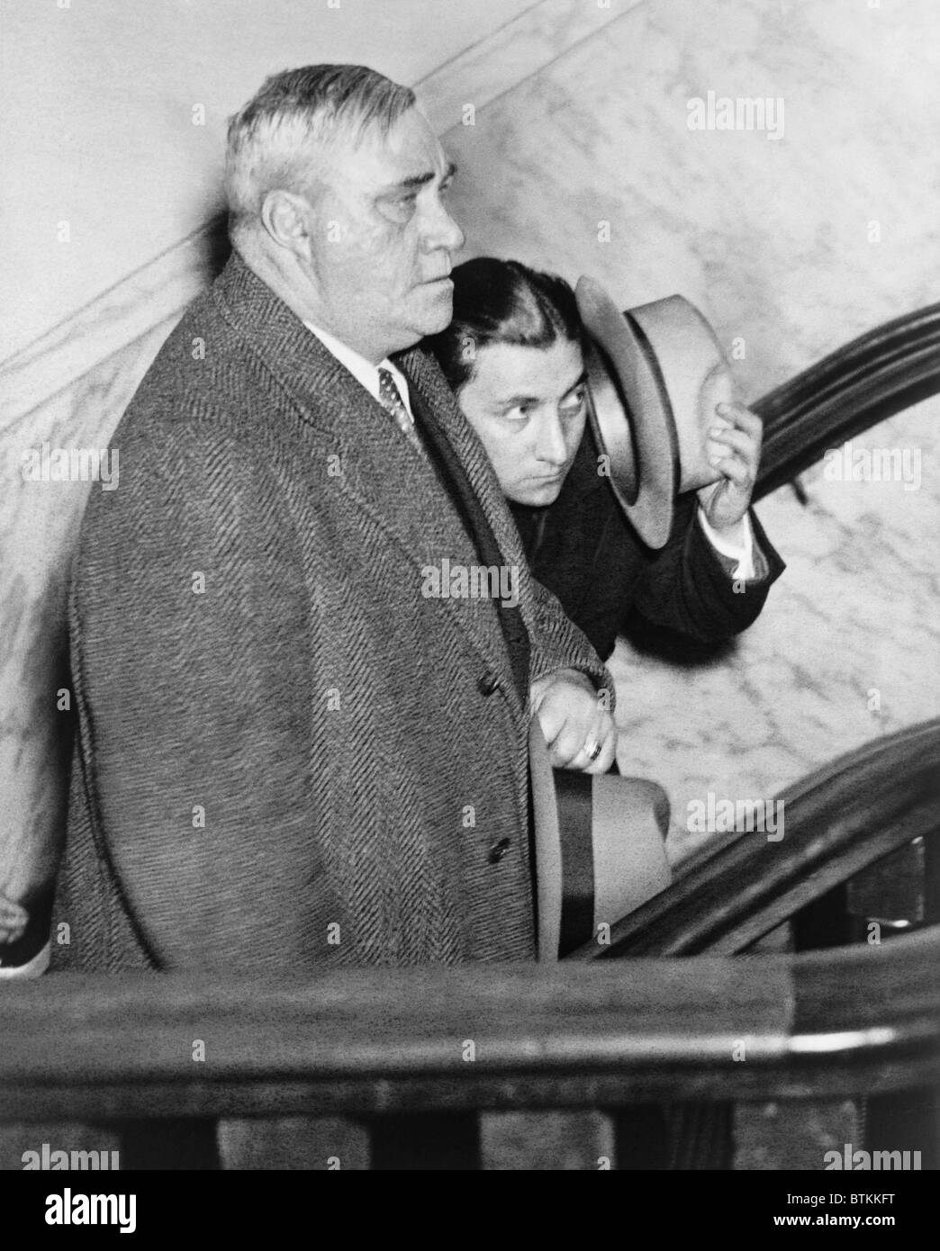 Irving Bitz (1903-1980), dans le but de protéger son visage de photographes lors de leur détention par un détective de police le 30 janvier 1933. Bitz est le principal suspect dans le meurtre de 1931 Legs Diamond. Banque D'Images