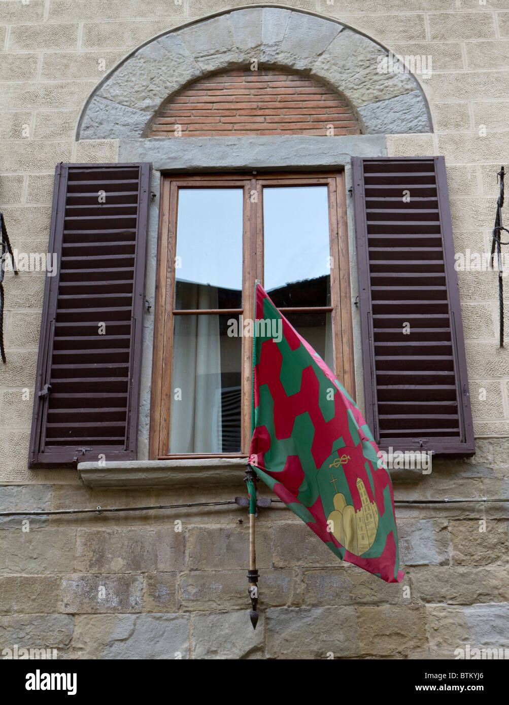 Détail d'une fenêtre à Arezzo montrant un drapeau rouge et vert Banque D'Images