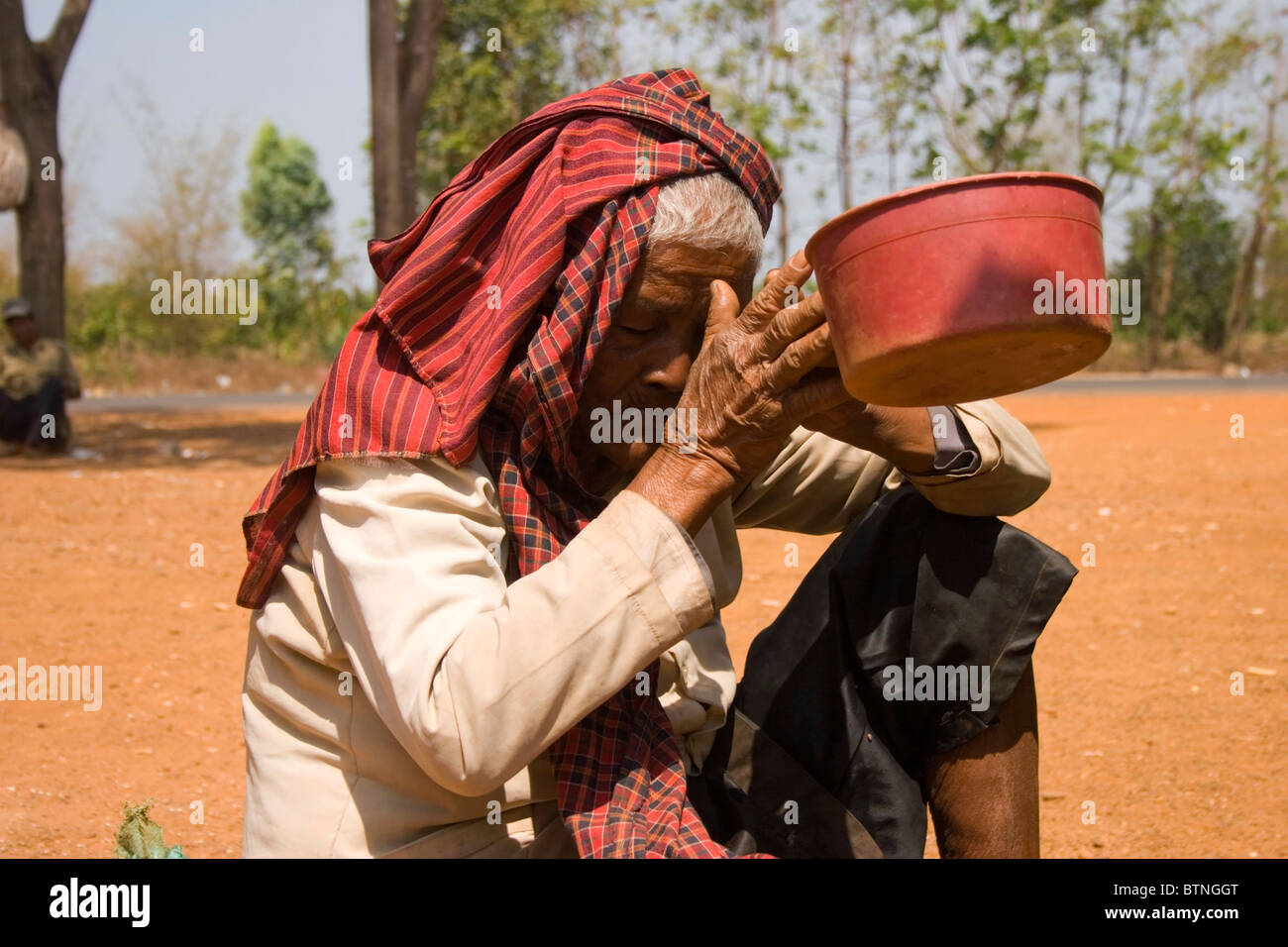 Une femme handicapée âgée a besoin d'argent pour l'alimentation et un fauteuil roulant dans la province de Kampong Cham, au Cambodge. Banque D'Images