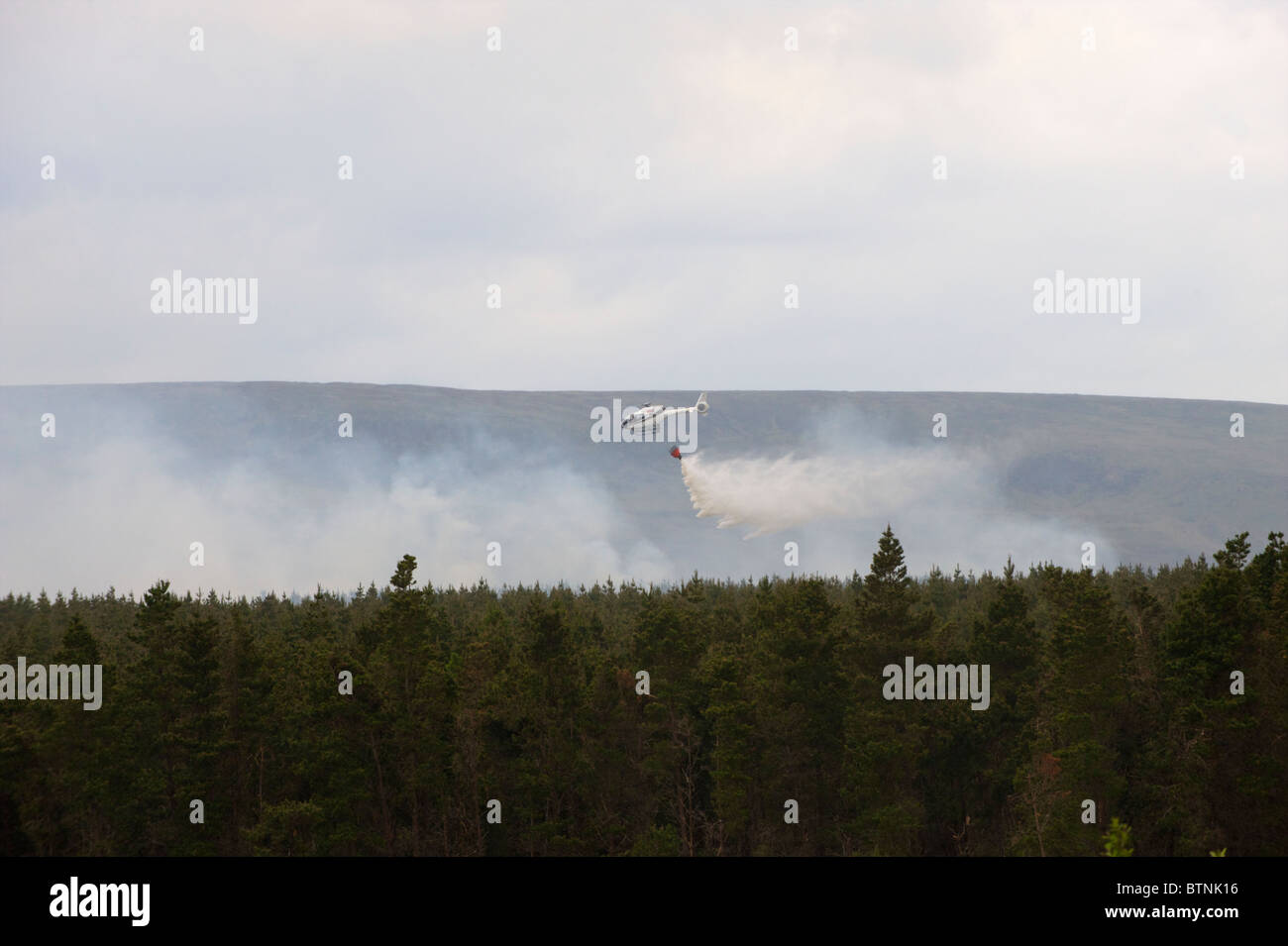 Un hélicoptère verse de l'eau sur un incendie de forêt dans la région de Mayo, Irlande Banque D'Images