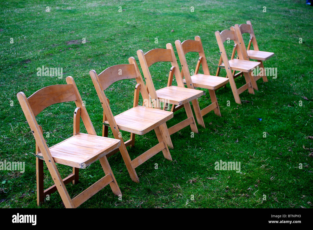 Chaises pliantes disposées en ligne droite jusqu'à l'extérieur Banque D'Images