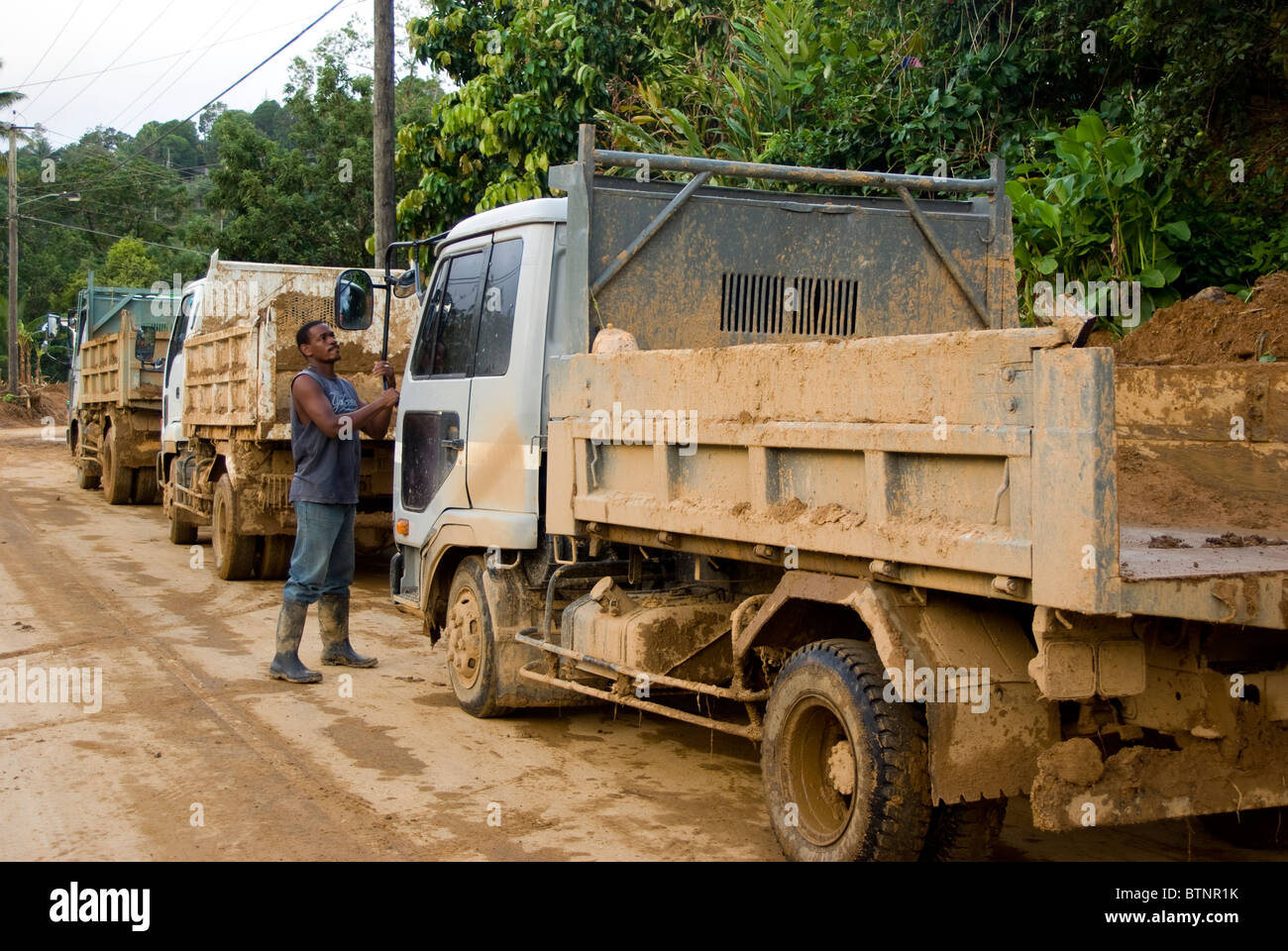 Pilote vérifie sur le camion en attente dans la rue boueuse pendant le