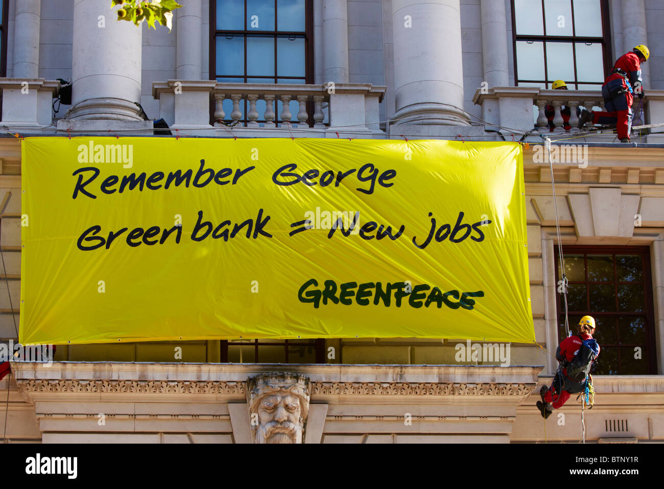 Quatre manifestants de Greenpeace l'échelle du bâtiment du trésor et déploie une bannière pour mettre en évidence les questions écologiques Banque D'Images