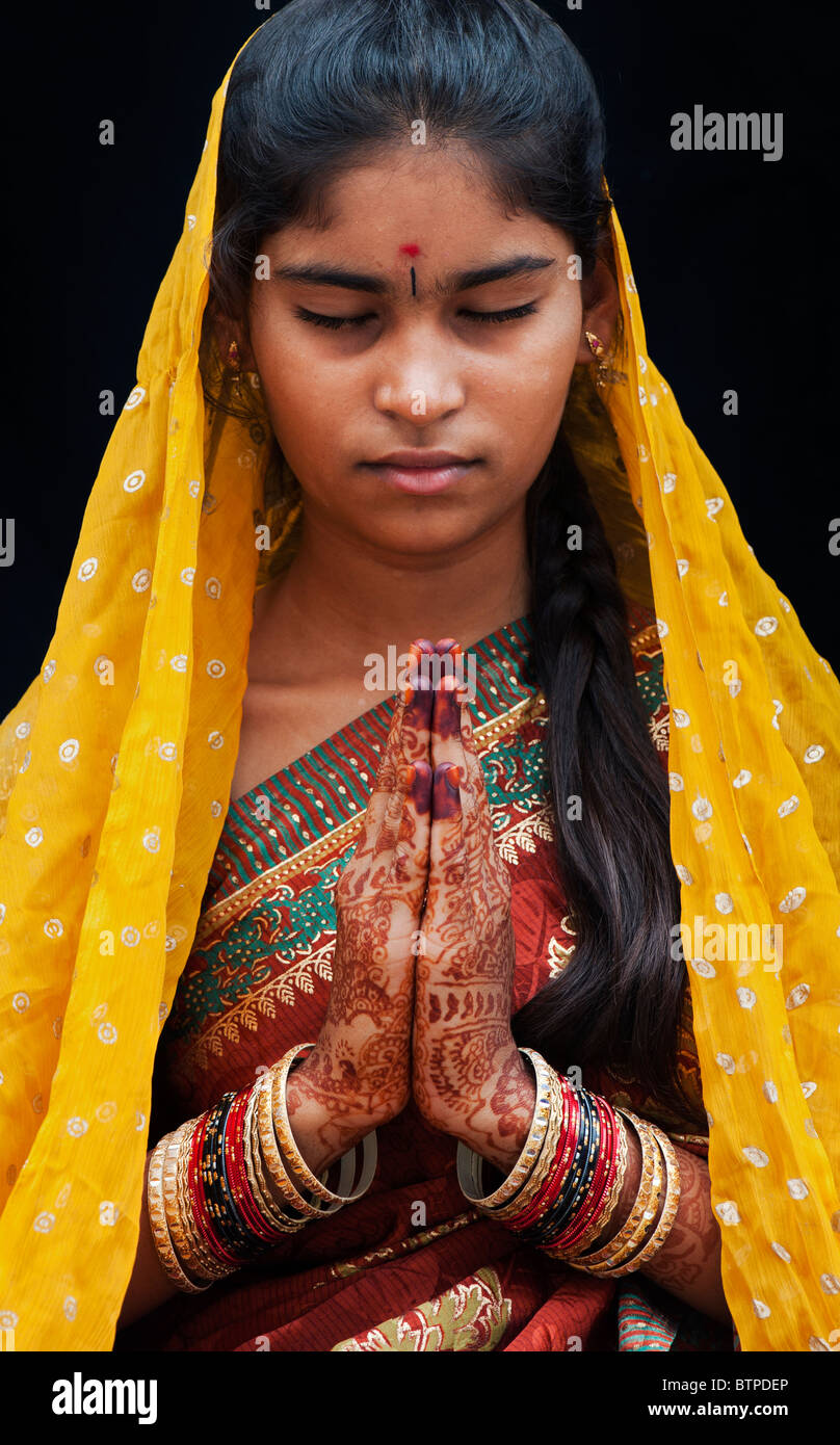 Indian girl wearing silk sari traditionnel au henné la prière les mains. L'Inde Banque D'Images
