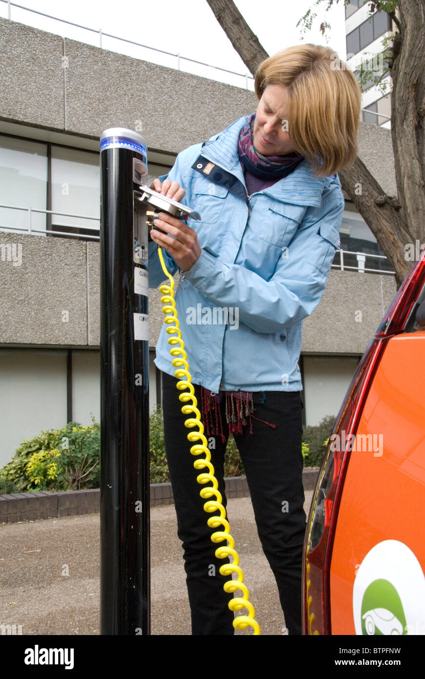 Femme de brancher en véhicule électrique EV EV gratuitement au parking Bay South Bank London UK GoGo locations de véhicules électriques Banque D'Images