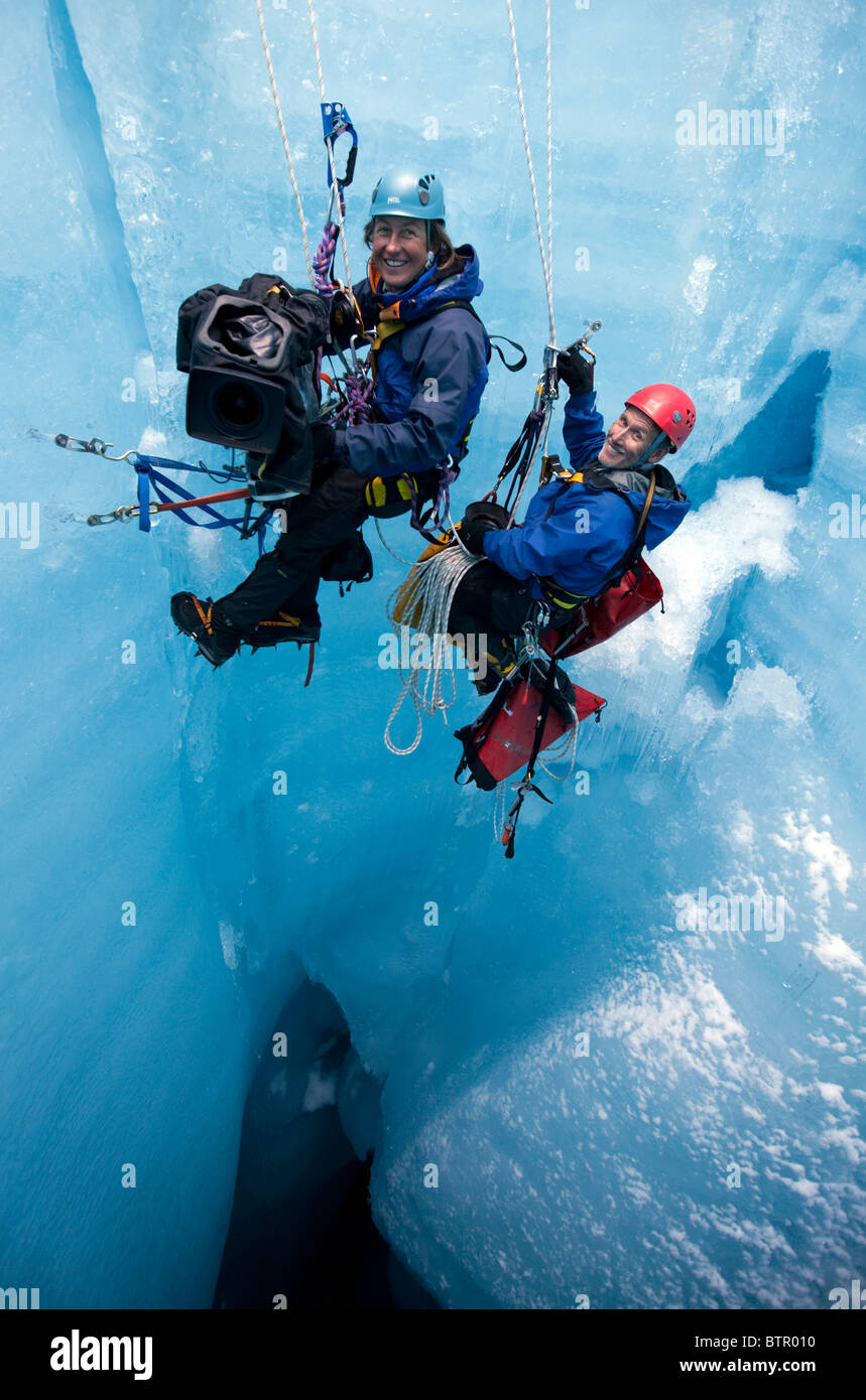 Justine Evans et Tim Fogg tournage profondément dans un moulin dans le ventre d'un glacier suspendu de manière précaire de corde. Banque D'Images