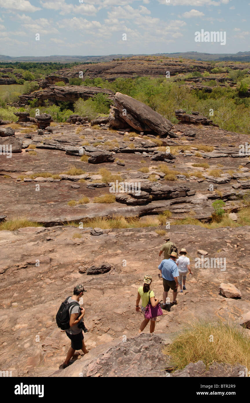 L'Australie, l'Ubirr, groupe de personnes de la randonnée à travers le paysage rocheux Banque D'Images