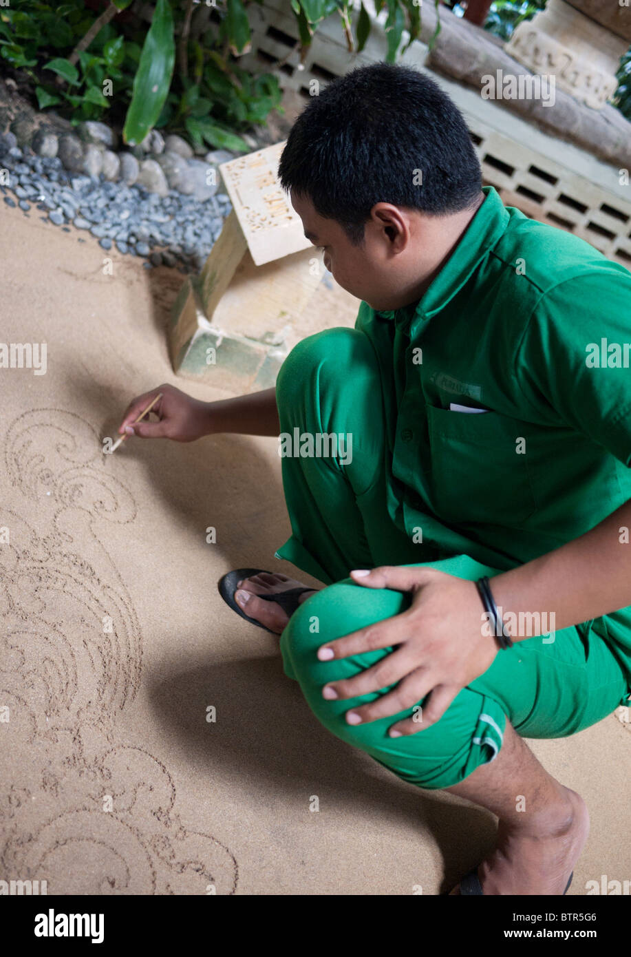 L'homme écrit dans le sable dans l'Hôtel Melia Bali Nusa Dua Bali Indonésie Banque D'Images