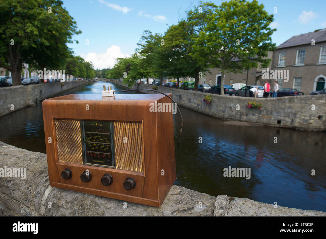 Un mobilier ancien en bois radio électrique à gauche sur un mur par le fleuve à Westport, Comté de Mayo, Irlande Banque D'Images