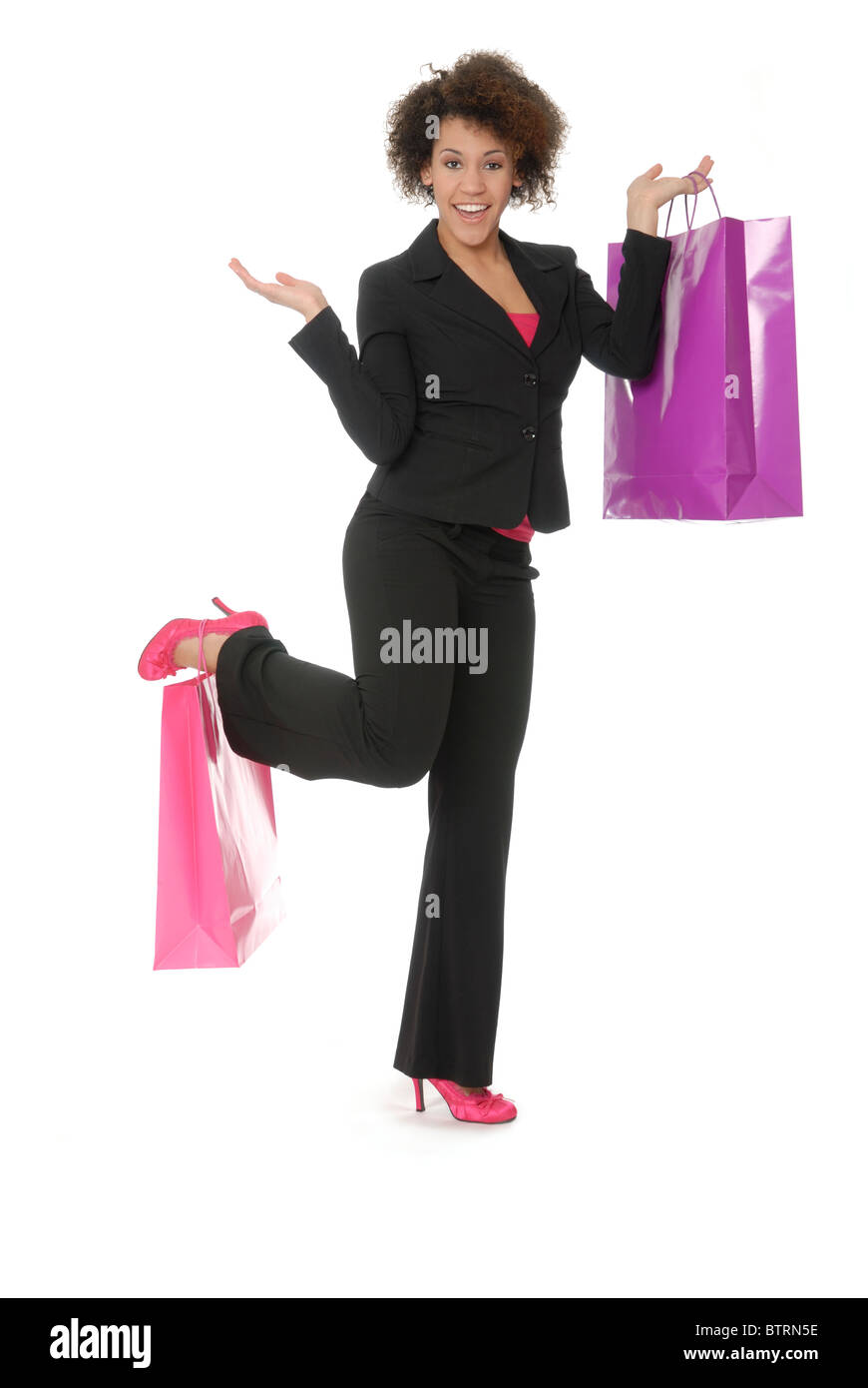 Belle, jeune femme enthousiaste shopper, tenant un sac dans sa main et sur son service ou à pied. Model est mixte. Banque D'Images