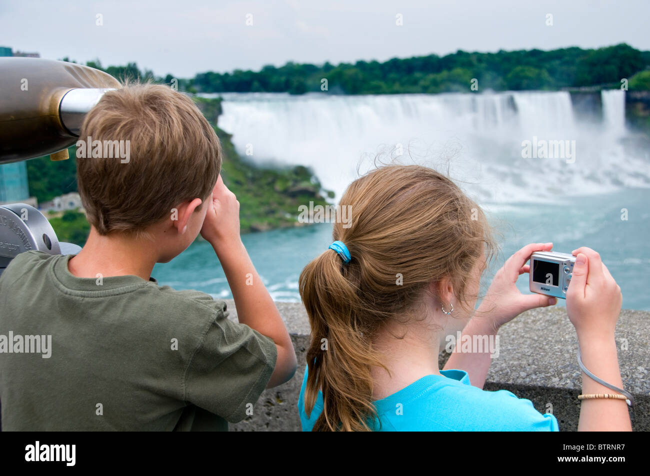 Enfants à Niagara Falls en Amérique du Nord, debout sur le côté canadien, avec l'American Falls dans l'arrière-plan Banque D'Images