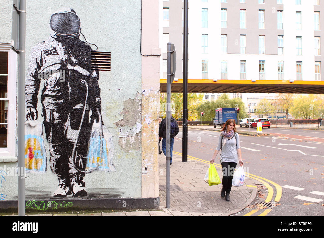 Street art graffiti urbain SPQR spaceman avec supermarché shopping bags par artiste SPQR dans la région de Stokes Croft 2010 Bristol Banque D'Images