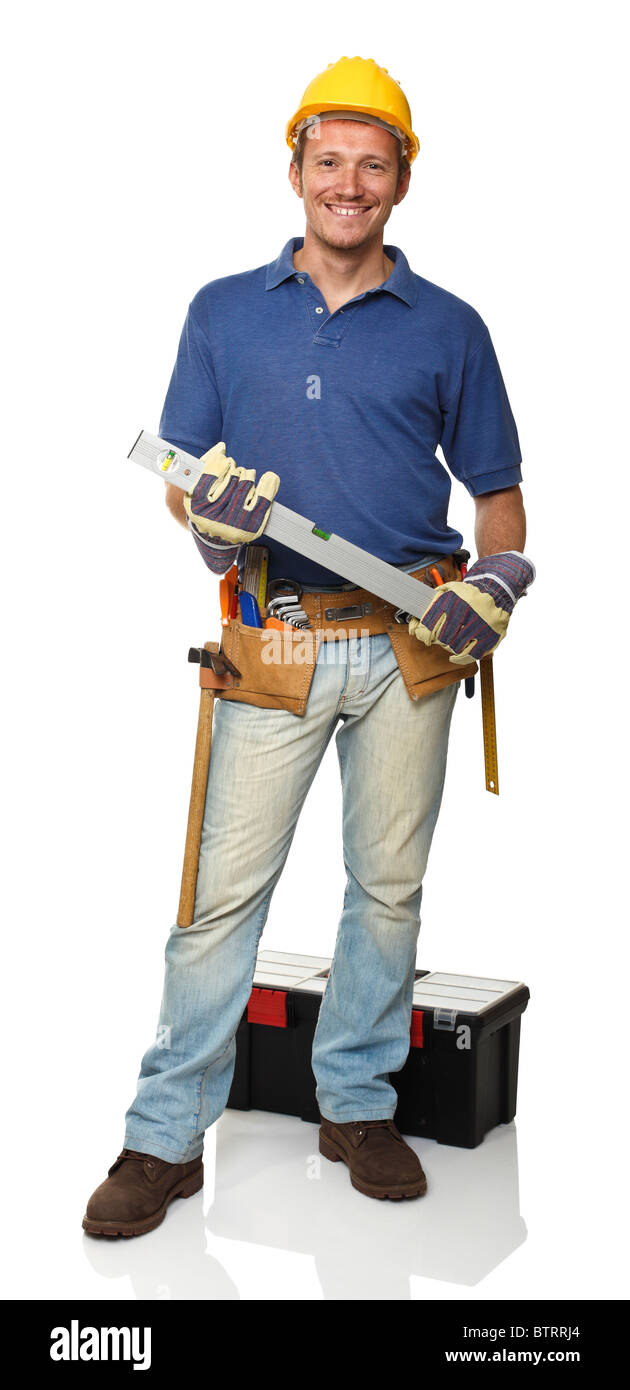 Smiling standing handyman holding spirit level on white Banque D'Images