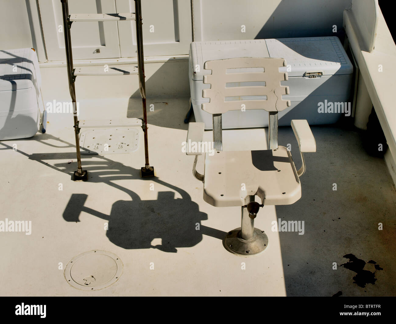 Bateau de pêche en haute mer avec échelle et siège sur le pont avec les ombres Banque D'Images