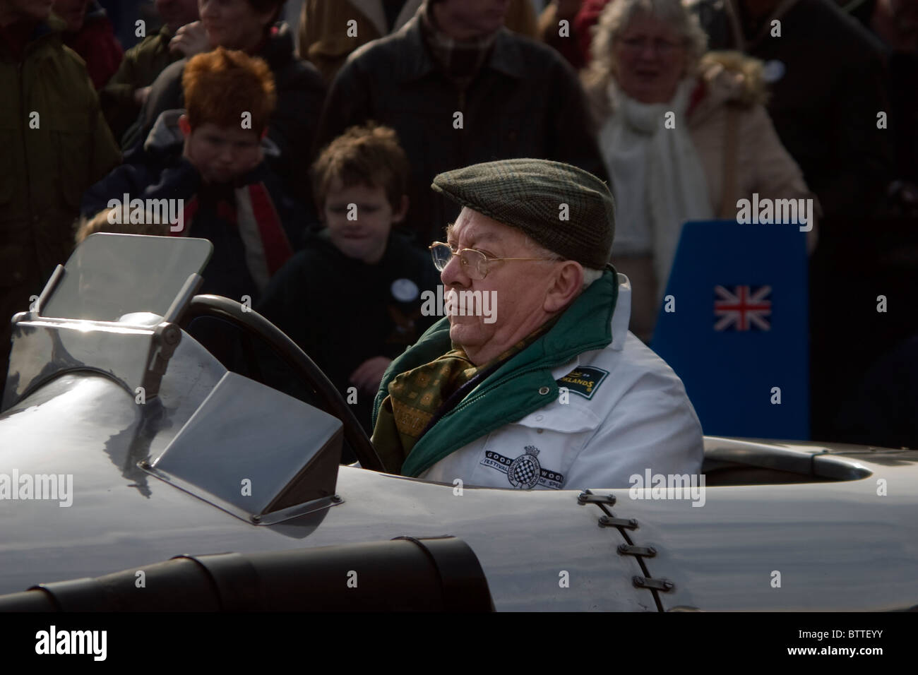 Un homme âgé motoring ventilateurs dans une voiture de course vintage classic à Brooklands Weybridge, Surrey, UK Banque D'Images