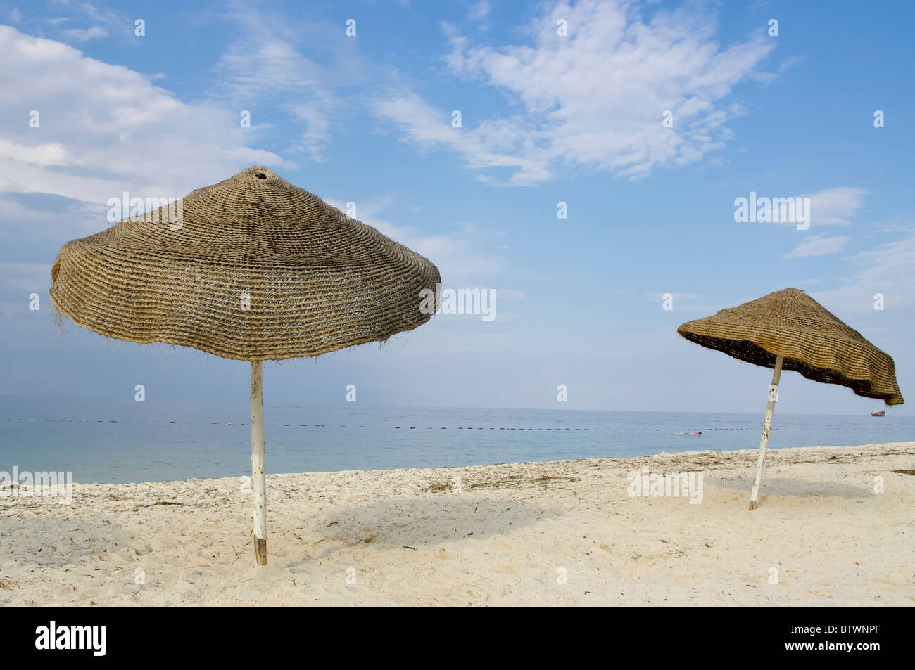 Deux parasols à la plage de sable ensoleillée Banque D'Images