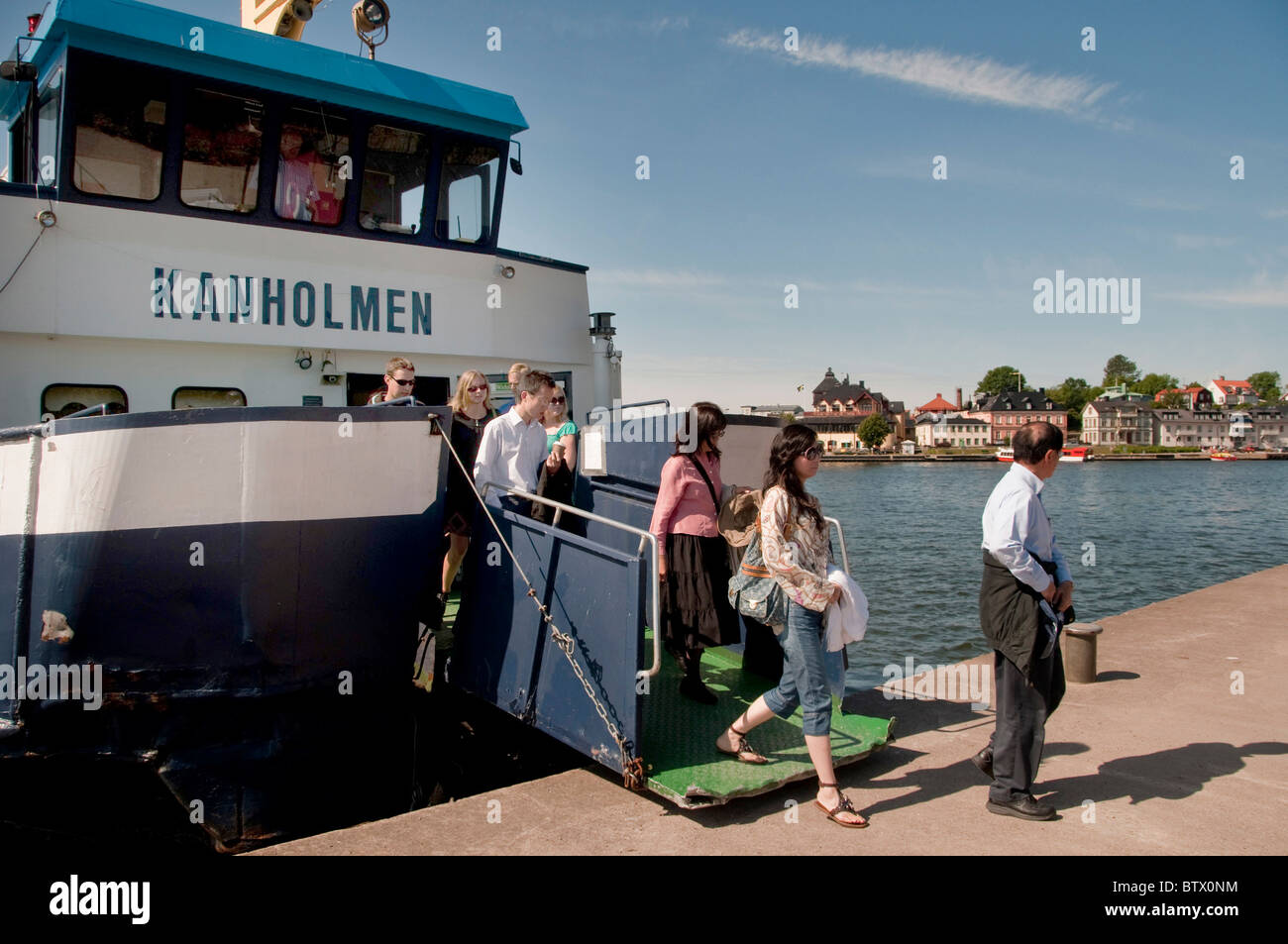 Les touristes débarquent le ferry entre ville de Vaxholm en arrière-plan et le château de Vaxholm Banque D'Images