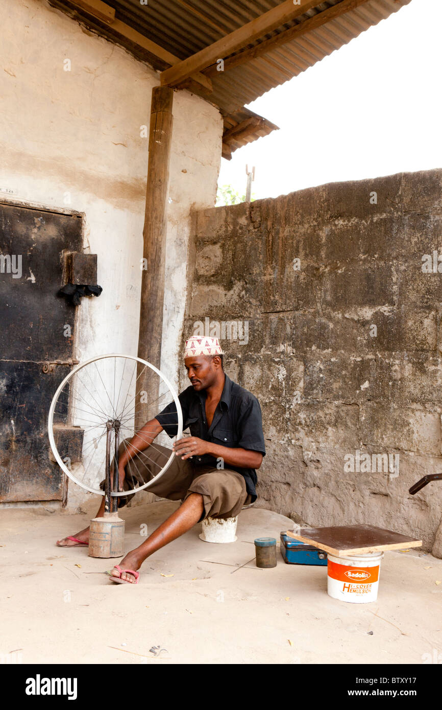 Homme africain la fixation d'une roue de vélo. Dar es Salaam Tanzanie Banque D'Images