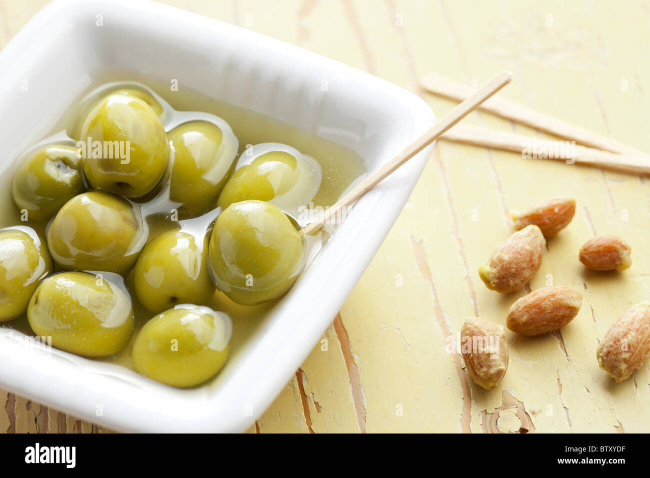 Les olives vertes dans le bol en céramique ancienne table Banque D'Images