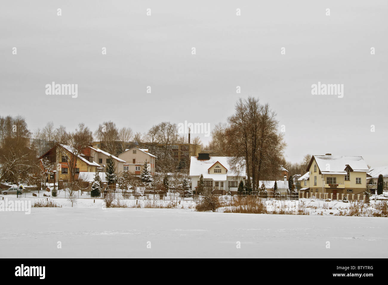 Le pays maisons couvertes de neige sur la rive de la glace d'un lac. Banque D'Images
