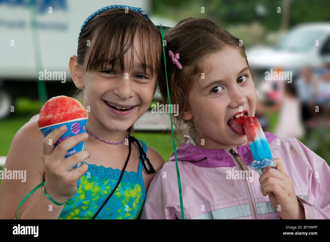 Deux filles de 8 ans profitez de la crème glacée (ICE) dans le cadre d'un festival à Wakefield, Massachusetts, USA Banque D'Images