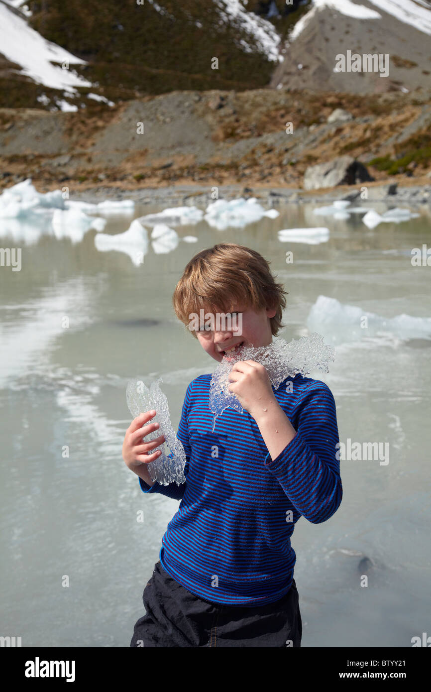 Boy eating ice des icebergs dans le terminal, le lac Glacier Hooker Hooker Valley, parc Aoraki / Mt Cook National Park, New Zealand Banque D'Images