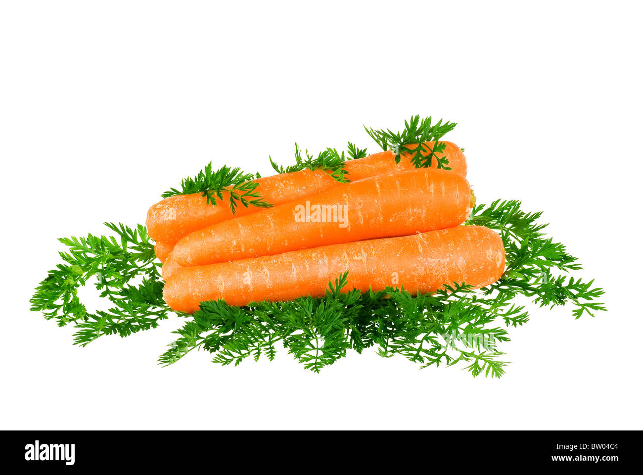 Les carottes empilées avec des feuilles autour de sur fond blanc Banque D'Images