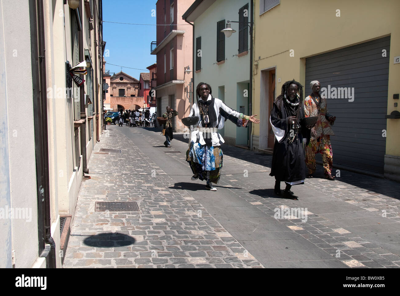 La tribu de l'Afrique de l'Éthiopie noir en costume traditionnel de la danse dans la rue à mendier pour de l'argent pour l'alimentation, dans une petite ville italienne Banque D'Images