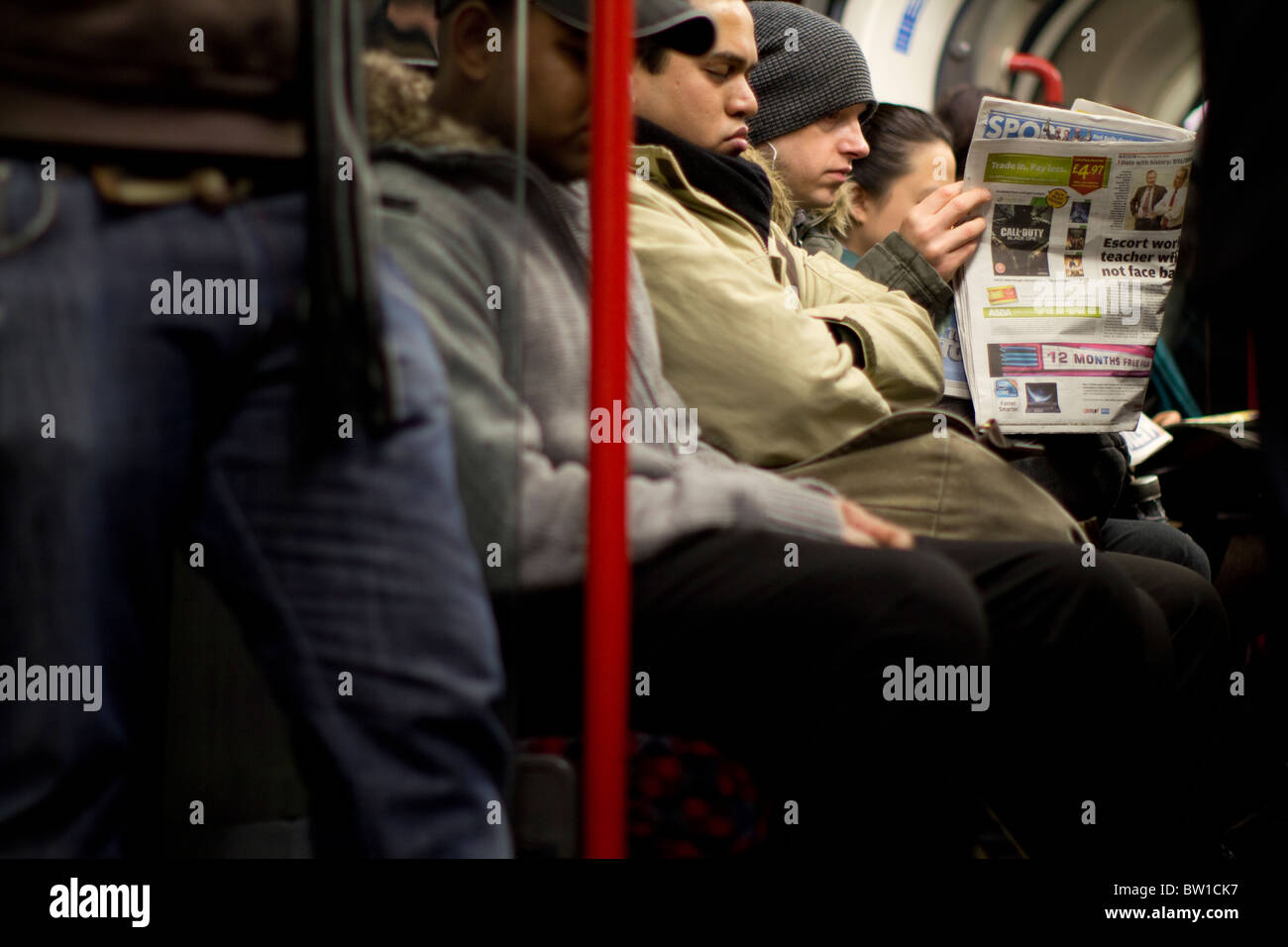 London Underground tube voyageurs passagers banlieusards, avec l'homme lisant le journal Métro Banque D'Images