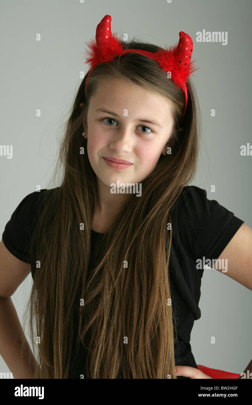 Dix ans, fille portant des cornes de diable rouge fancy dress. Banque D'Images