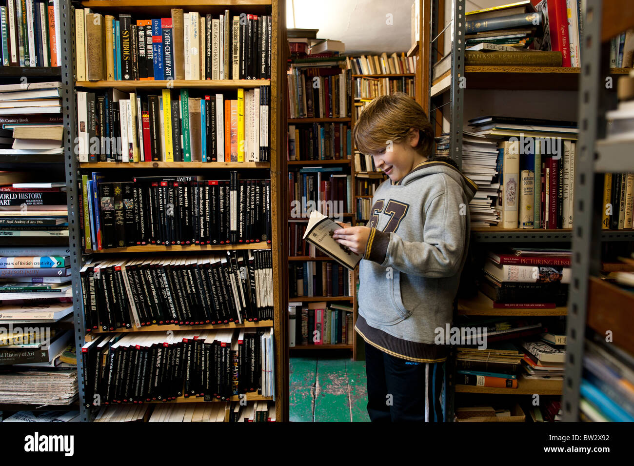 Un jeune garçon à la lecture d'un exemplaire d'Hamlet à l'Ystwyth Books nouveau et utilisé librairie indépendante, Aberystwyth Wales UK Banque D'Images