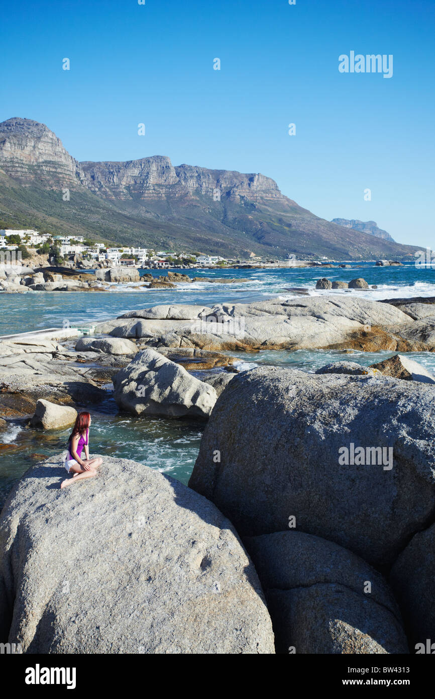 Femme à Camps Bay avec douze apôtres en arrière-plan, Cape Town, Western Cape, Afrique du Sud Banque D'Images