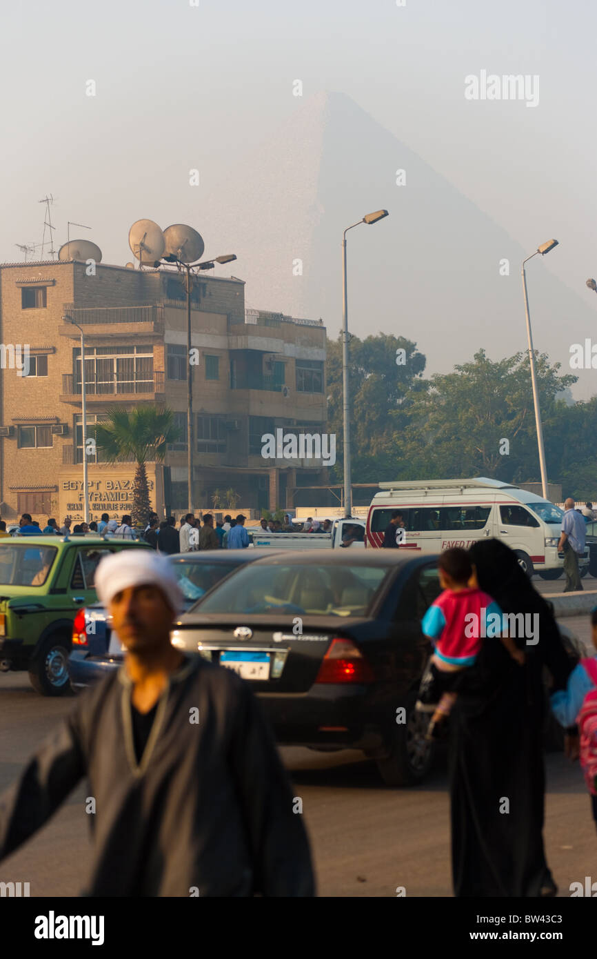 La pyramide de Khéops est visible par l'épaisse couche de brume, de poussière et de pollution de l'air le smog de l'agitation et de la circulation rue poussiéreuse Banque D'Images