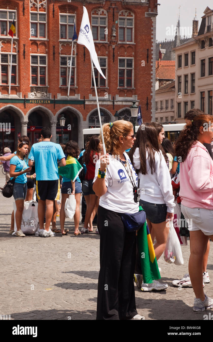 Markt, Bruges, Belgique, Europe. Les touristes shopping guide touristique avec drapeau dans la ville historique Banque D'Images