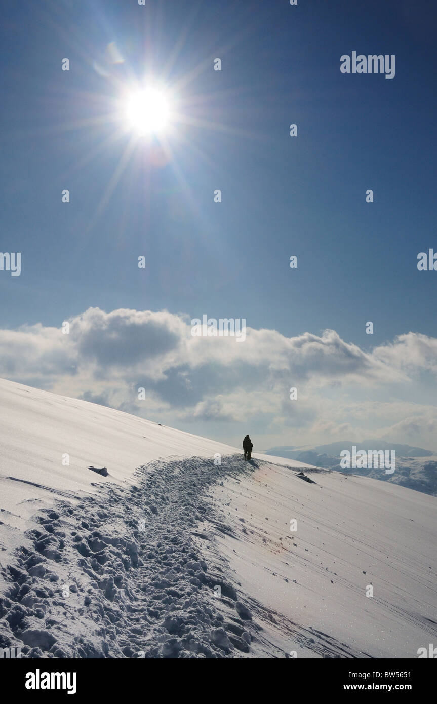 Soleil d'hiver et des traces de pas dans la neige sur la montagne Helvellyn, dans le Lake District Banque D'Images