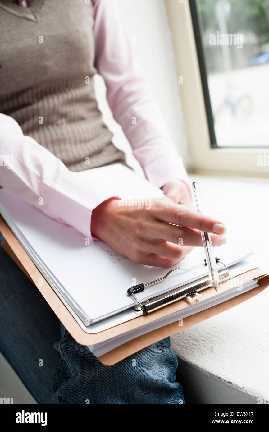 Hand holding clipboard close-up Banque D'Images