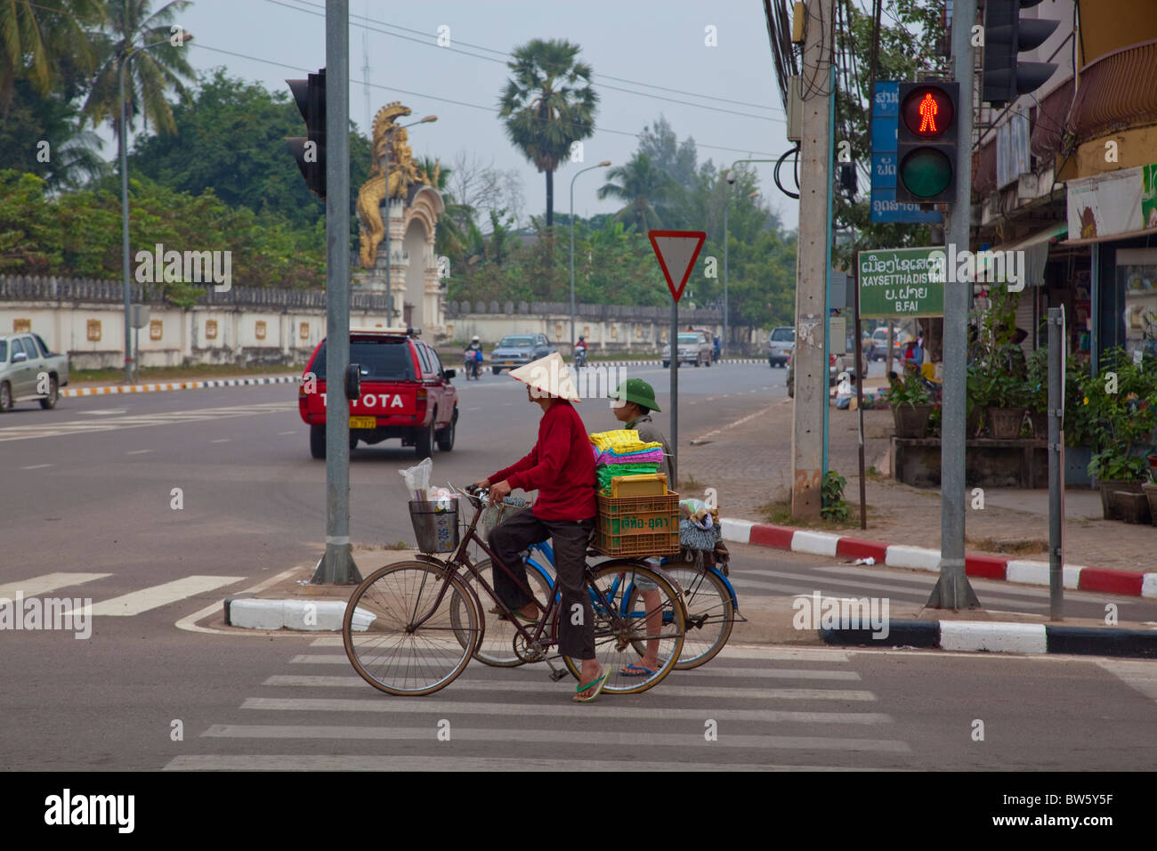 Les vélos d'attente à un feu de circulation dans le centre de Vientiane, Laos. Banque D'Images