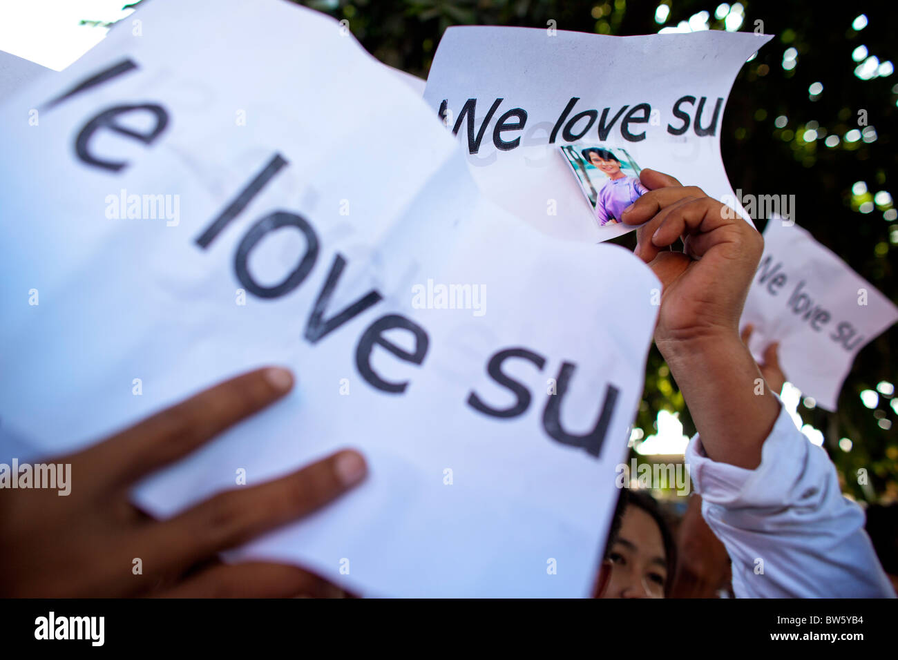 Les partisans d'Aung San Suu Kyi tenir des pancartes ' nous aimons su' au siège de la NLD. Banque D'Images